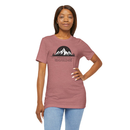 Woman wearing a mauve t-shirt with a mountain graphic on a white background