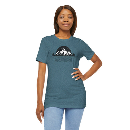 Woman wearing a teal t-shirt with a mountain graphic and text on a white background