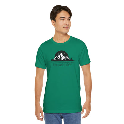 Man wearing a kelly  green t-shirt with a mountain graphic and text on a white background